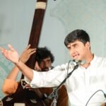 Aniruddh Aithal performing Hindustani classical vocal on stage with tanpura and tabla accompaniment